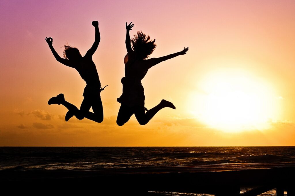 zwei Frauen glücklich Sprung Sonne Freiheit